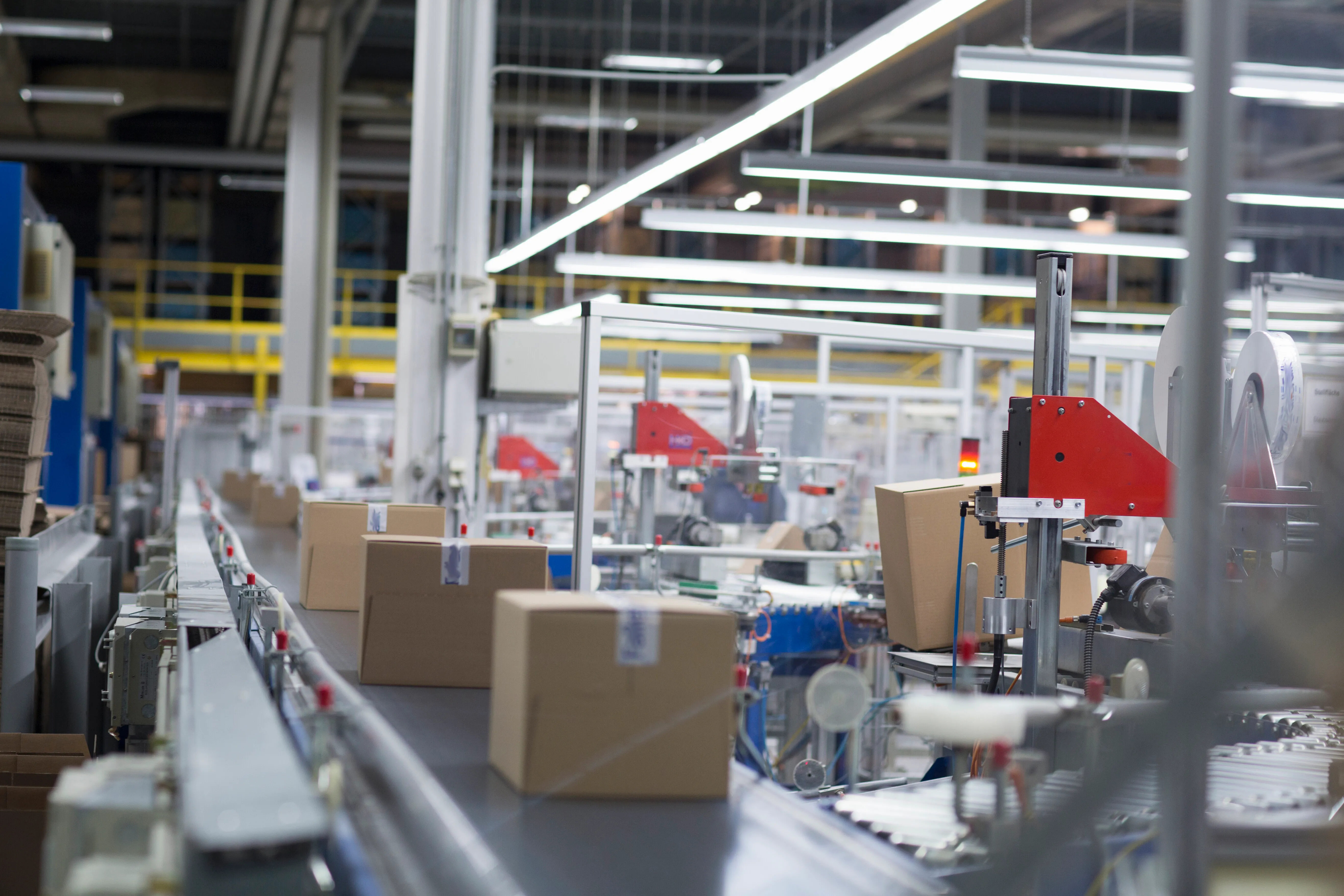 Karton kutuların bantlama makineleri arasından ilerlediği otomatik paketleme hattı.